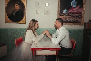 A playful interaction at a retro diner table with vintage artwork on the walls.