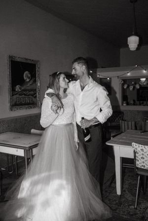 Black and white portrait in vintage diner setting showing romantic moment.