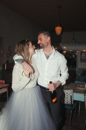 Retro-styled dance scene in dimly lit bar with couple in formal attire.