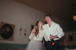 Vintage-inspired indoor wedding scene with historic portraits on wall.