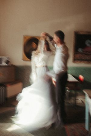 Blurred motion photo of couple dancing in vintage-style interior setting.