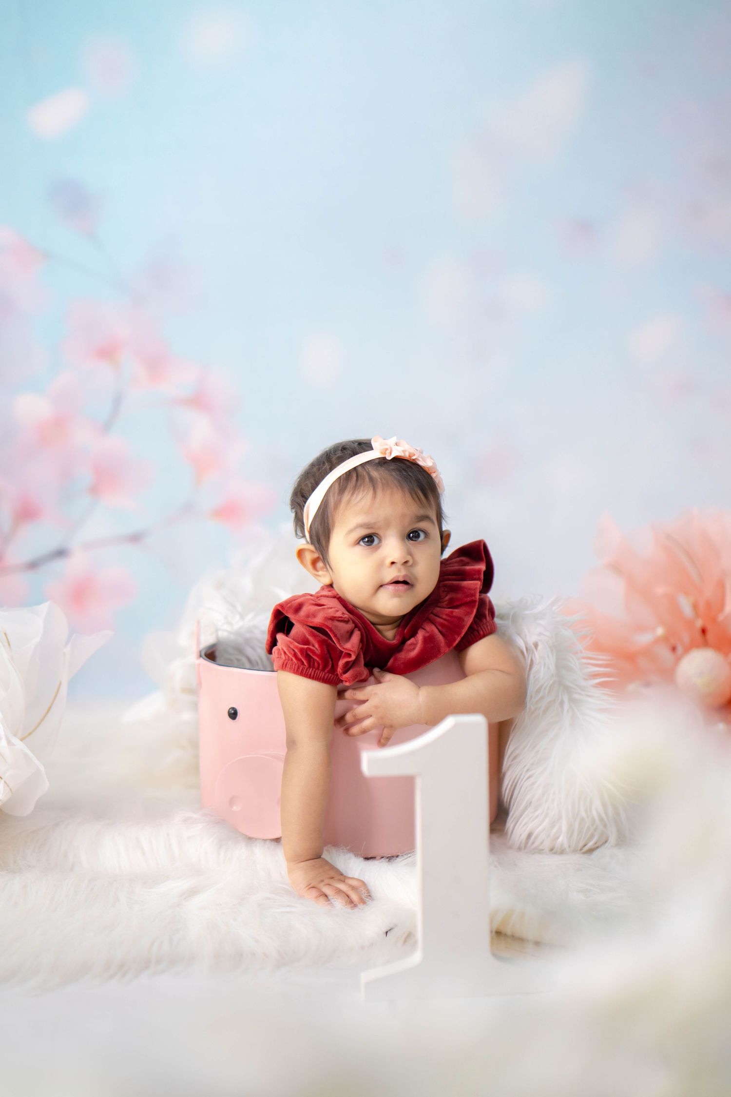 One-year-old baby clapping joyfully with cake all over face and hands