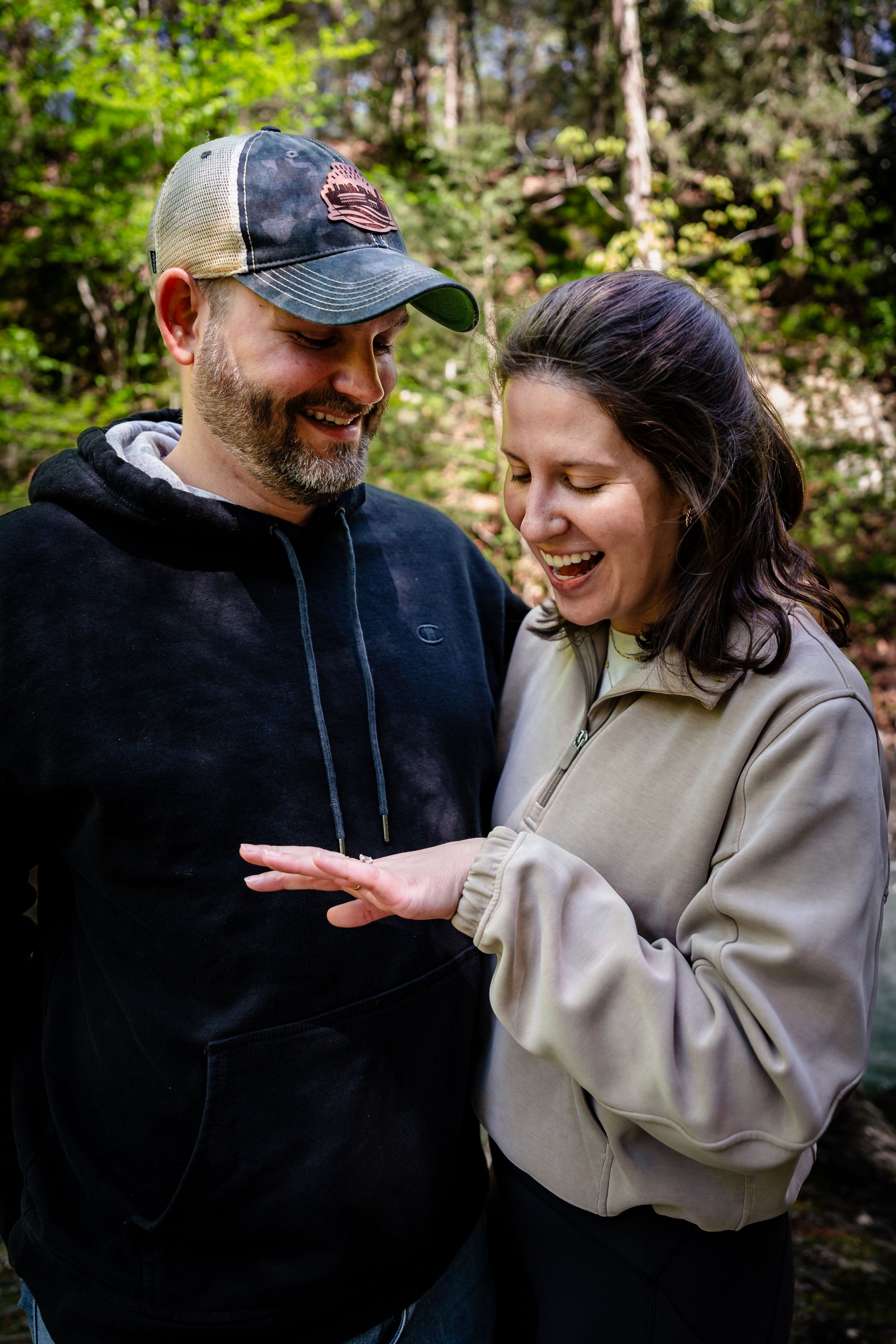A couple shares a joyful moment together outdoors while wearing casual clothing.