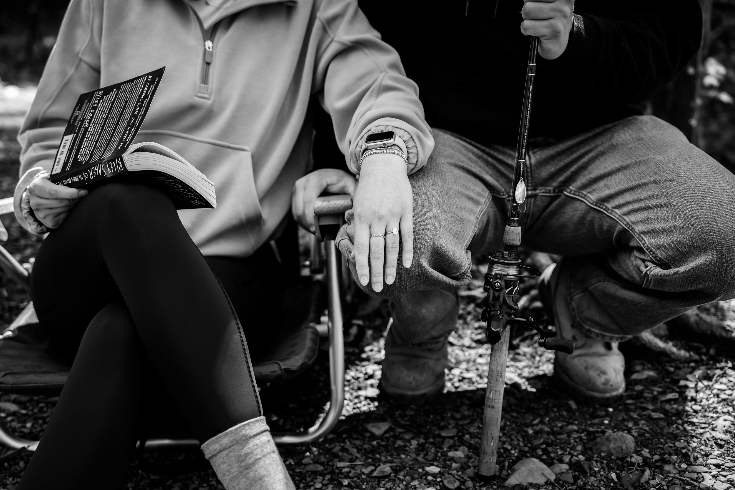 Close-up shot of people sitting on rocks in a wooded setting.