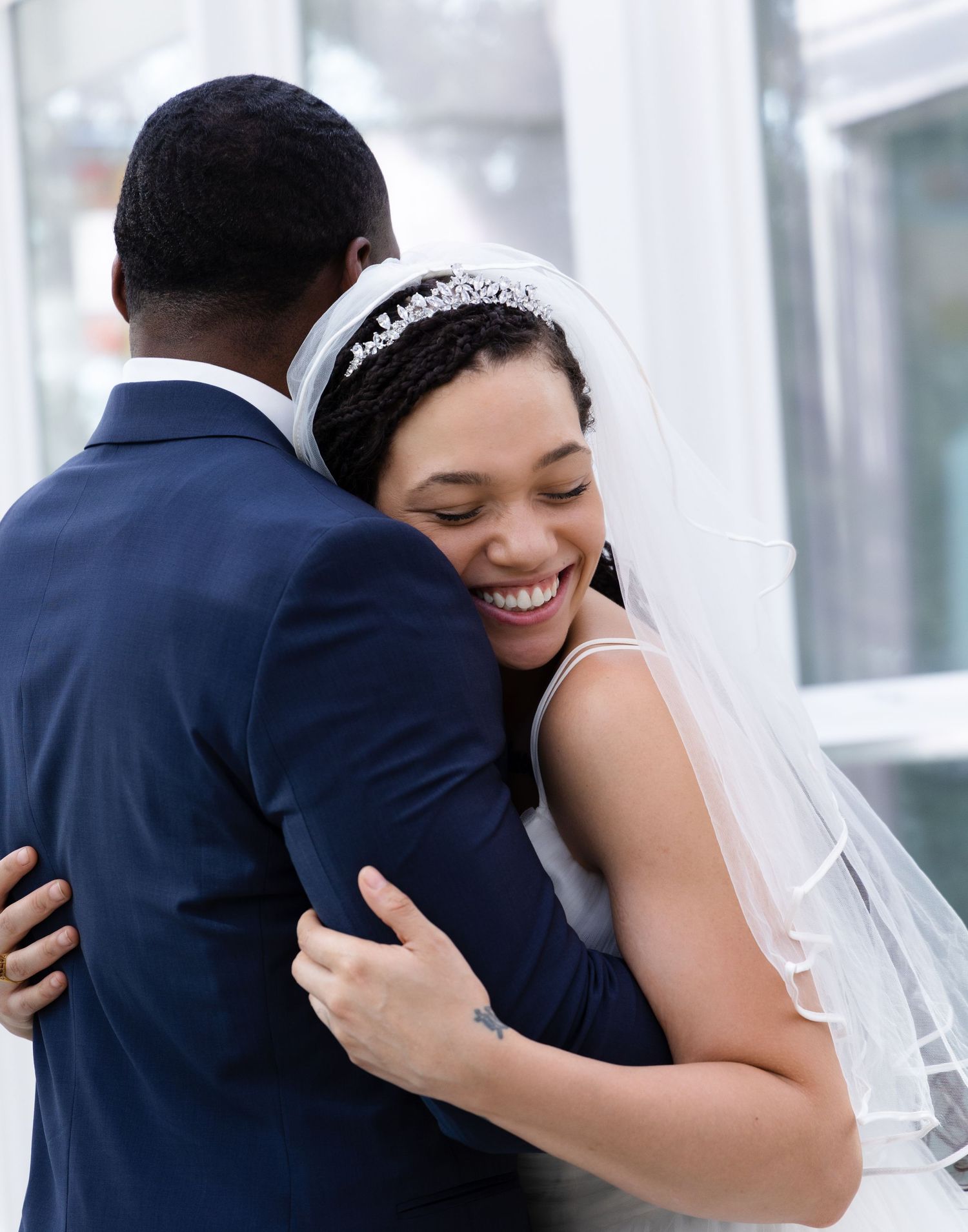 A tender embrace between newlyweds with the bride wearing a delicate veil and tiara.
