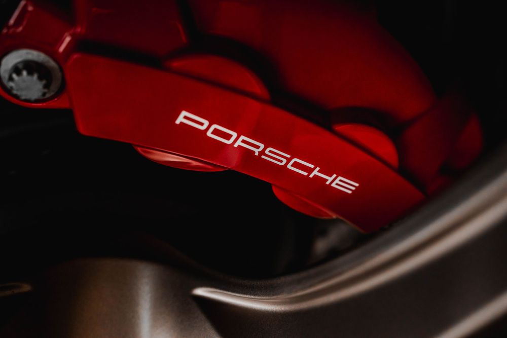 Close-up detail shot of red Porsche brake caliper with white lettering.