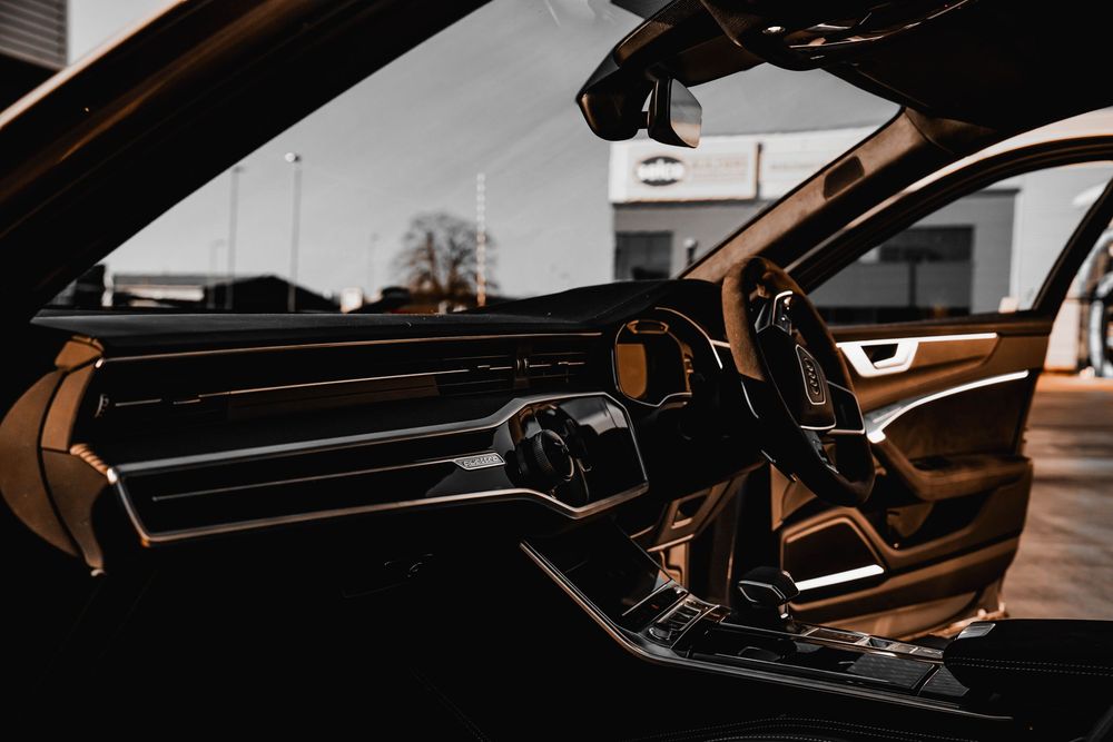 Interior dashboard view of an Audi RS6 showing modern digital displays and ambient lighting.