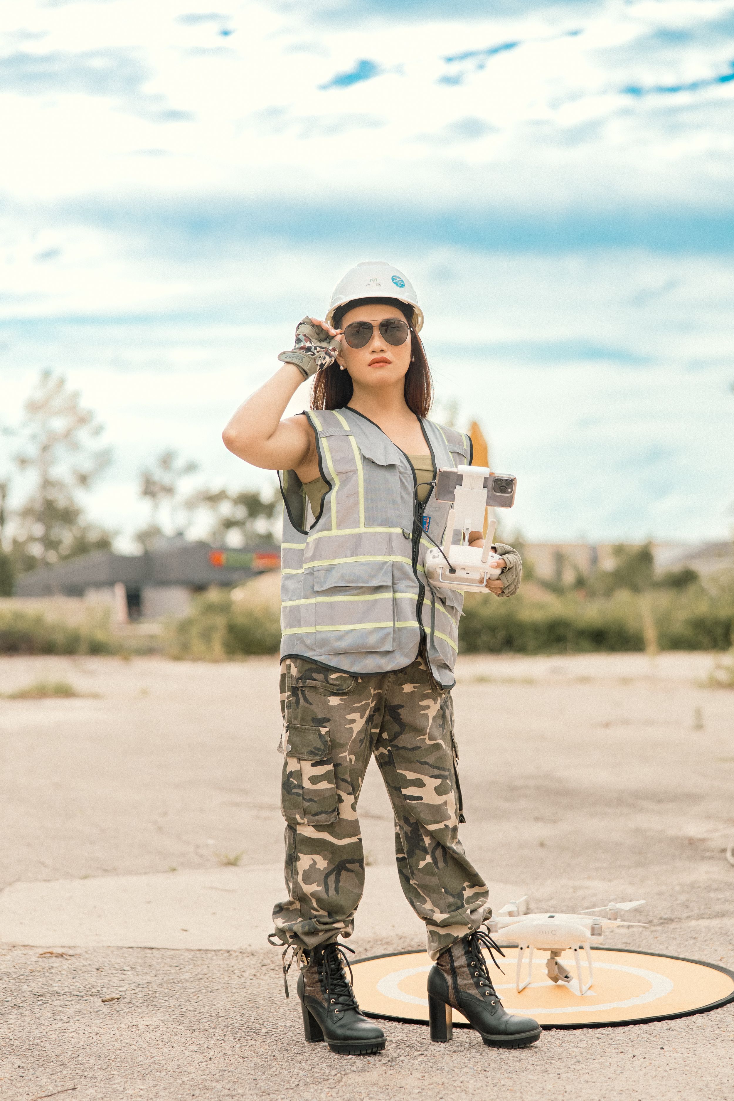 Safety inspector in reflective vest and camo pants examining work site.