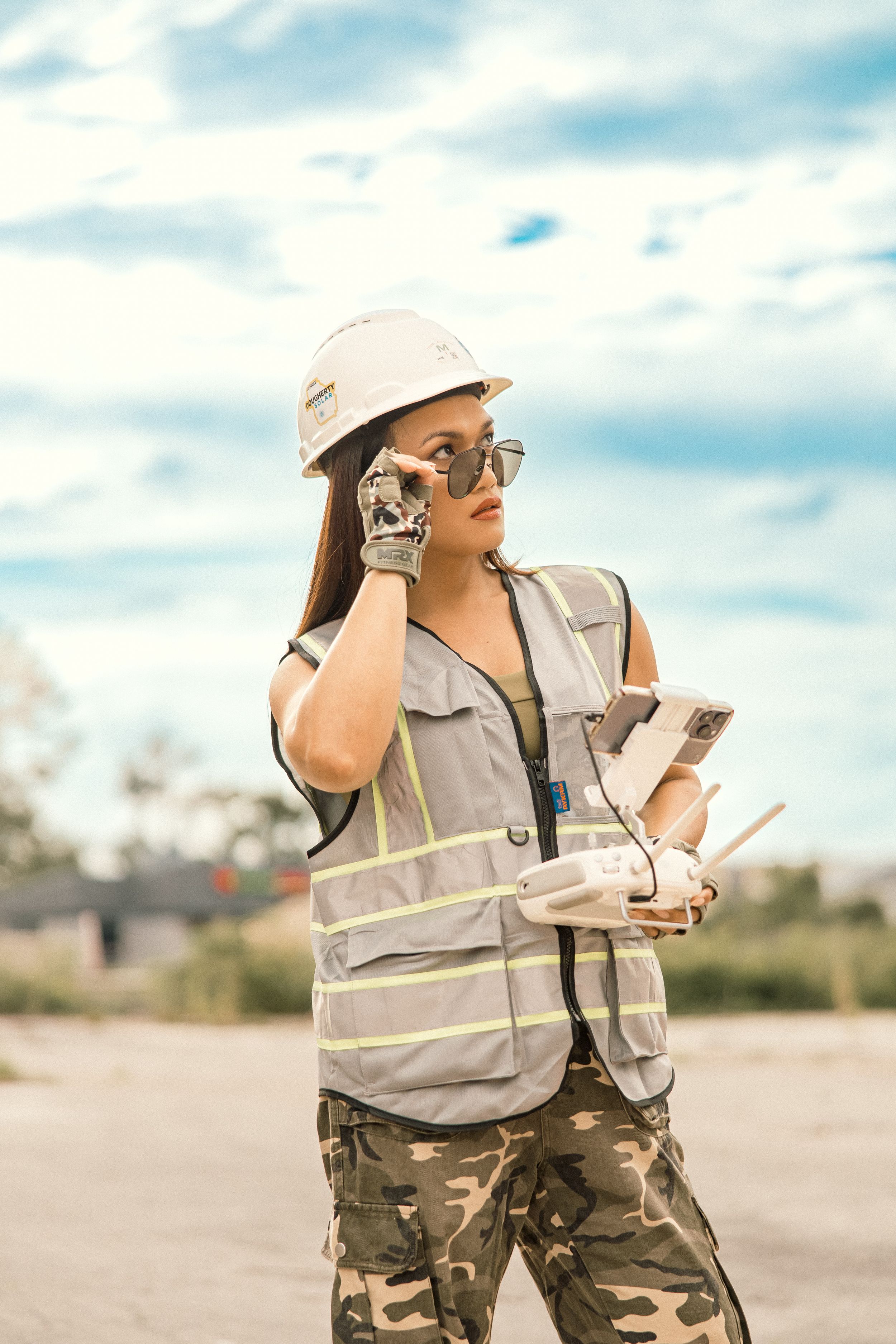 Site supervisor in protective gear checking documentation on sunny day.