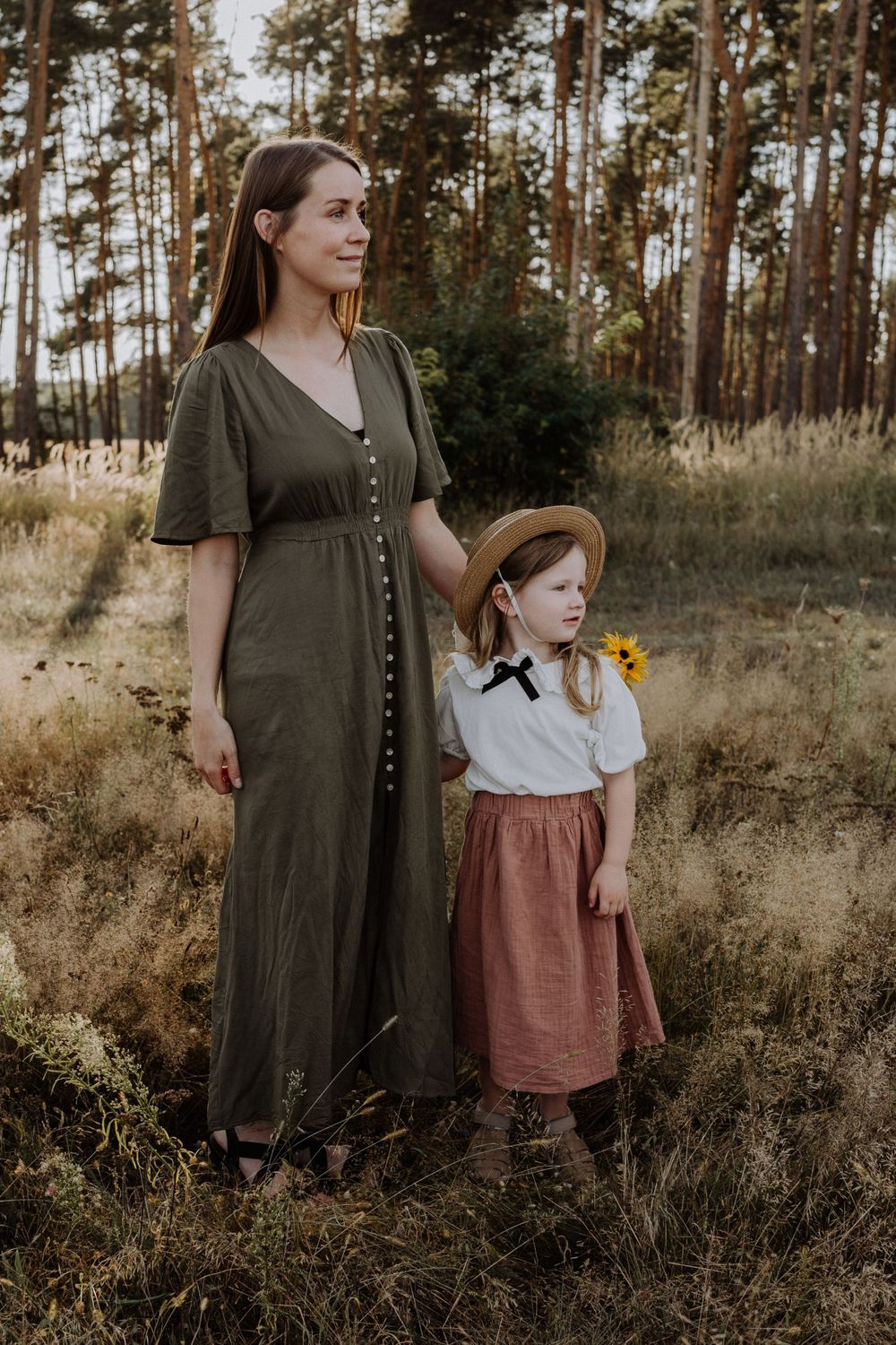 Forest portrait featuring long olive dress and vintage children's outfit with sunflowers.
