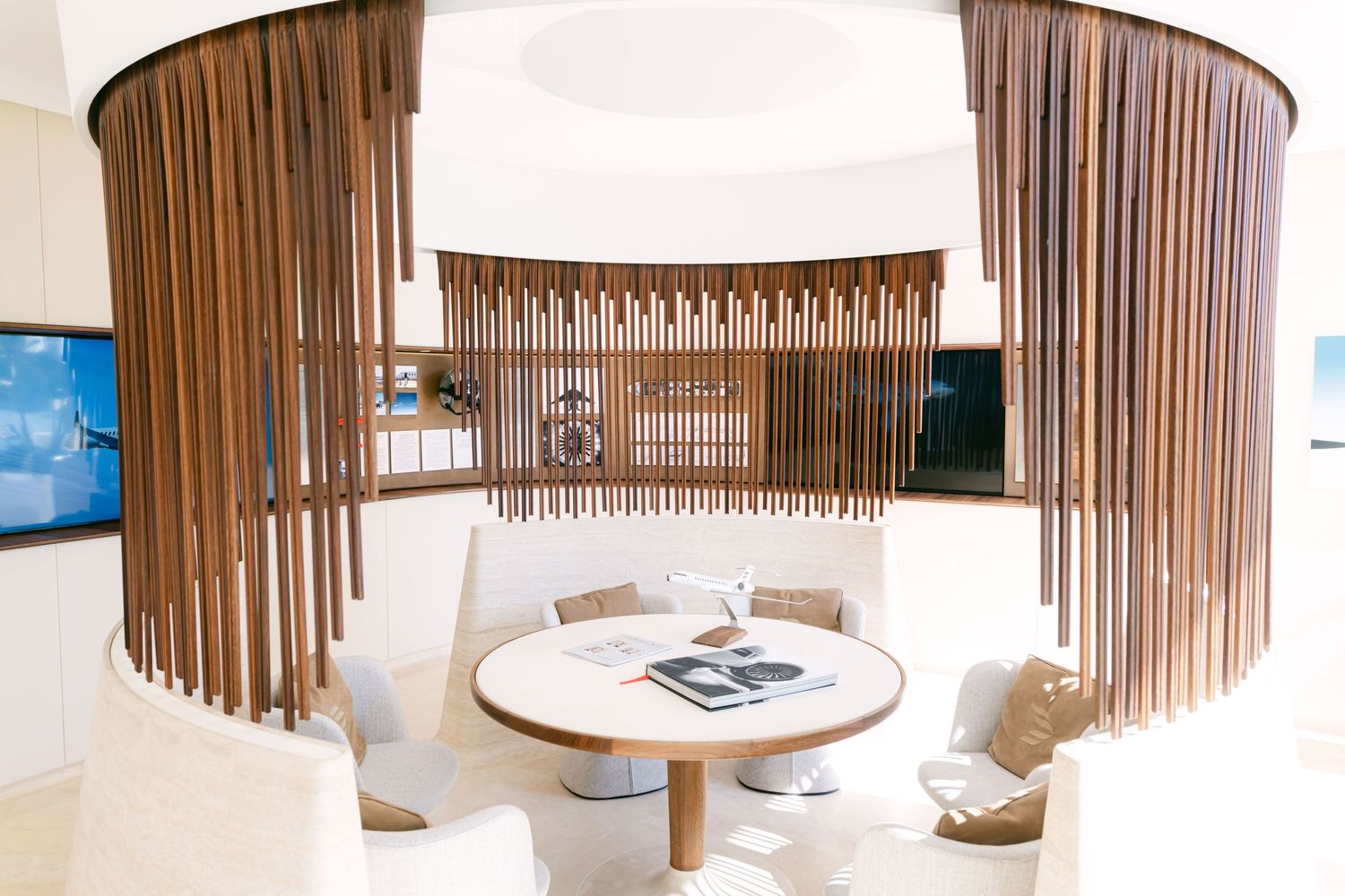 Modern office space with curved wooden slat walls and circular pendant lights creating an elegant architectural design.