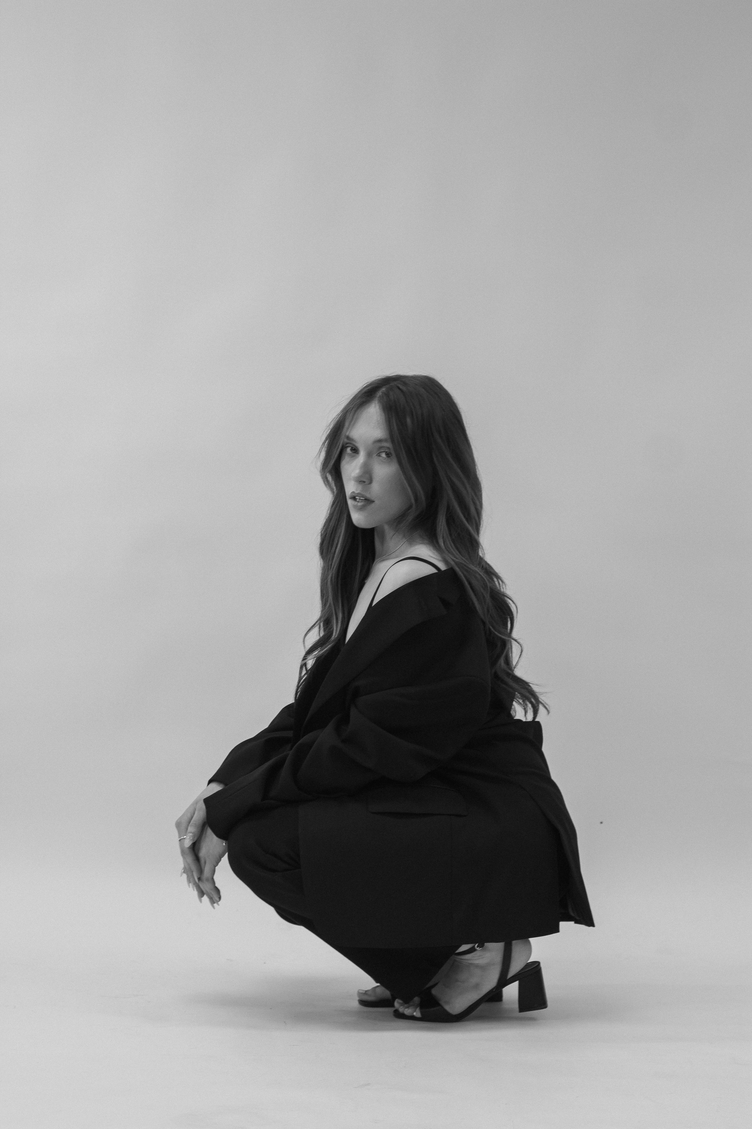 A person wearing a black off the shoulder top at a portrait photography session.