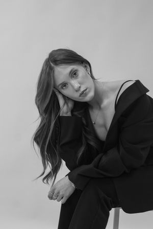 A person wearing a black off the shoulder top at a portrait photography session.