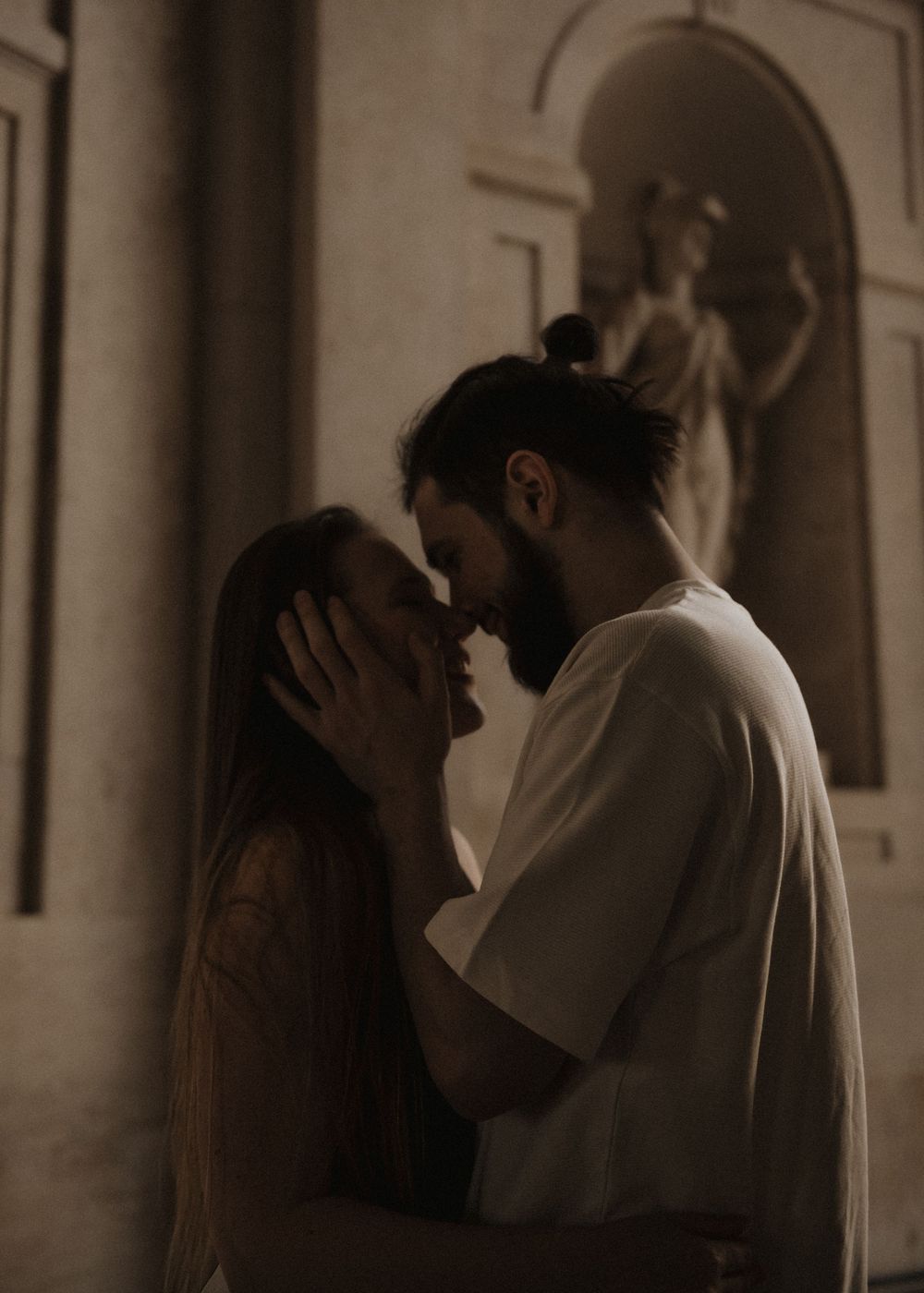 Sepia-toned sequence showing tender moments between a couple in an elegant hallway.
