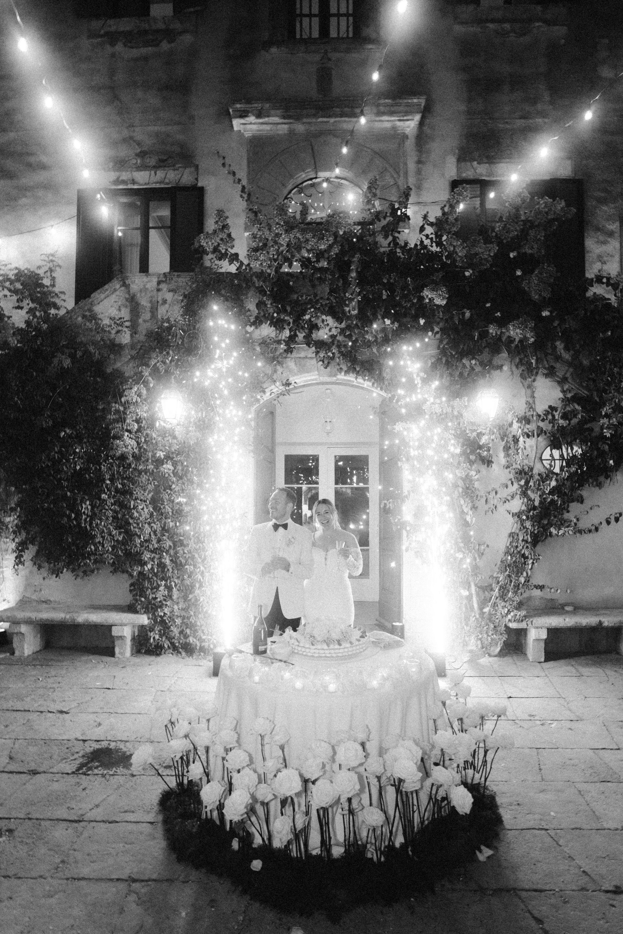 String lights illuminate a nighttime garden setting with decorative pathway lighting.