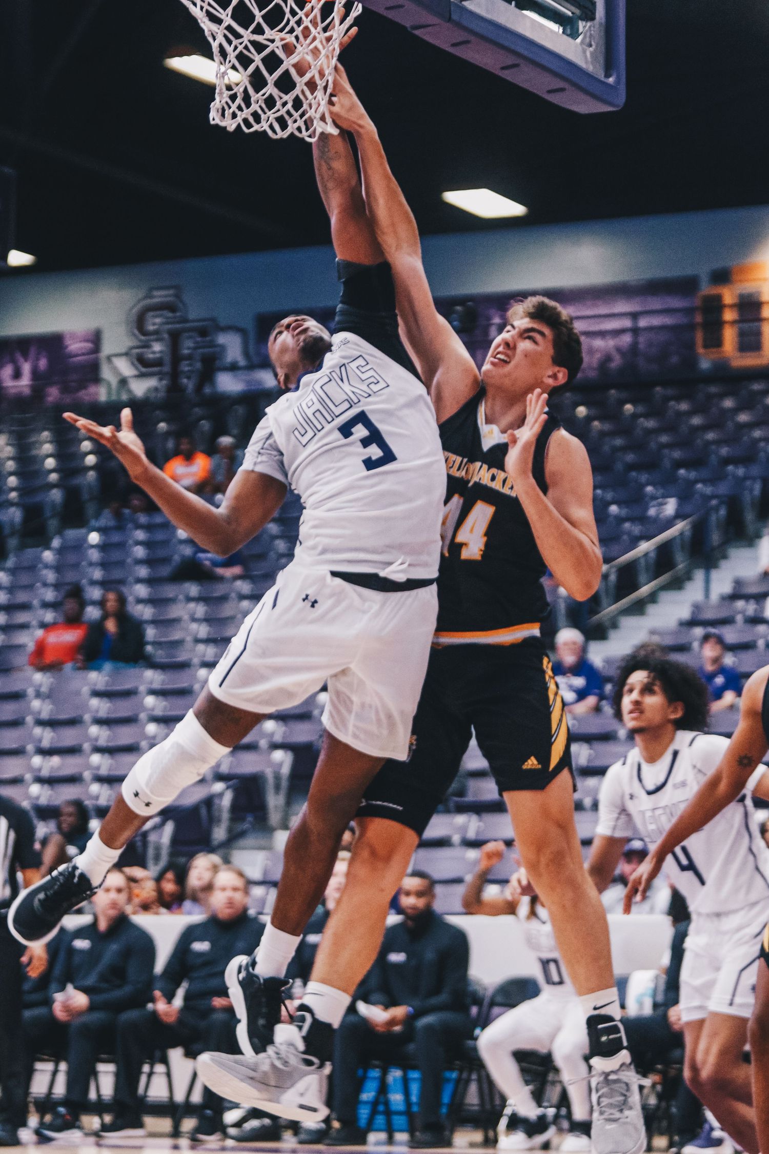 Basketball players competing for a rebound during an intense game.