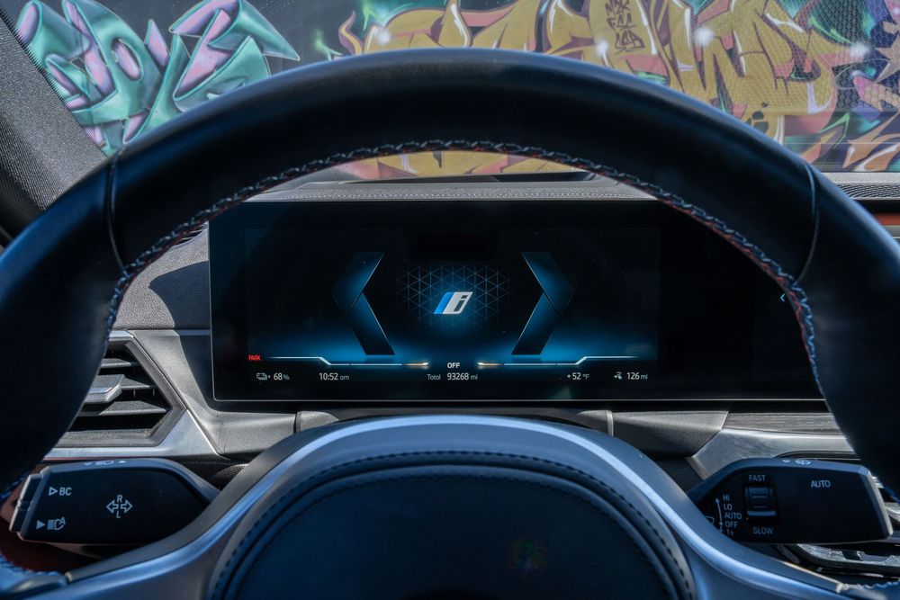 Modern car dashboard displays featuring digital gauges and blue ambient lighting in a luxury vehicle interior.