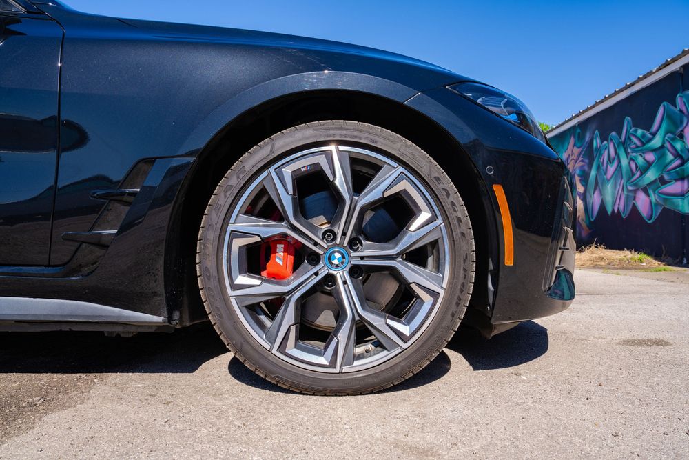 A series of car wheel closeup shots showing different angles of black alloy rims and tires against various backgrounds.