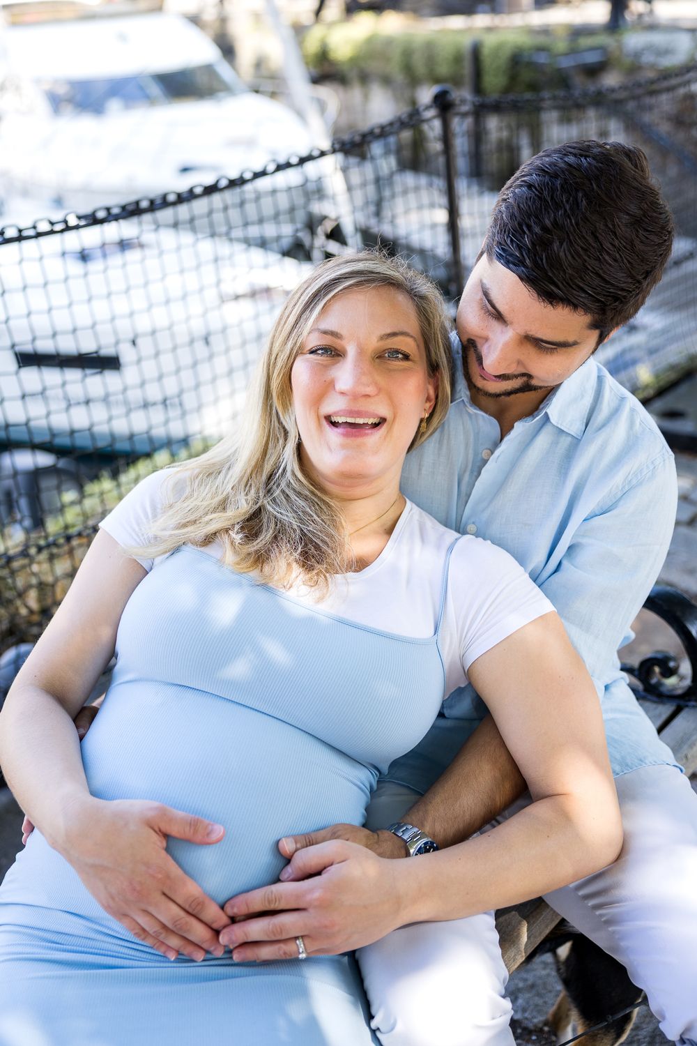 pregnant woman in a light blue dress smiling at camera
