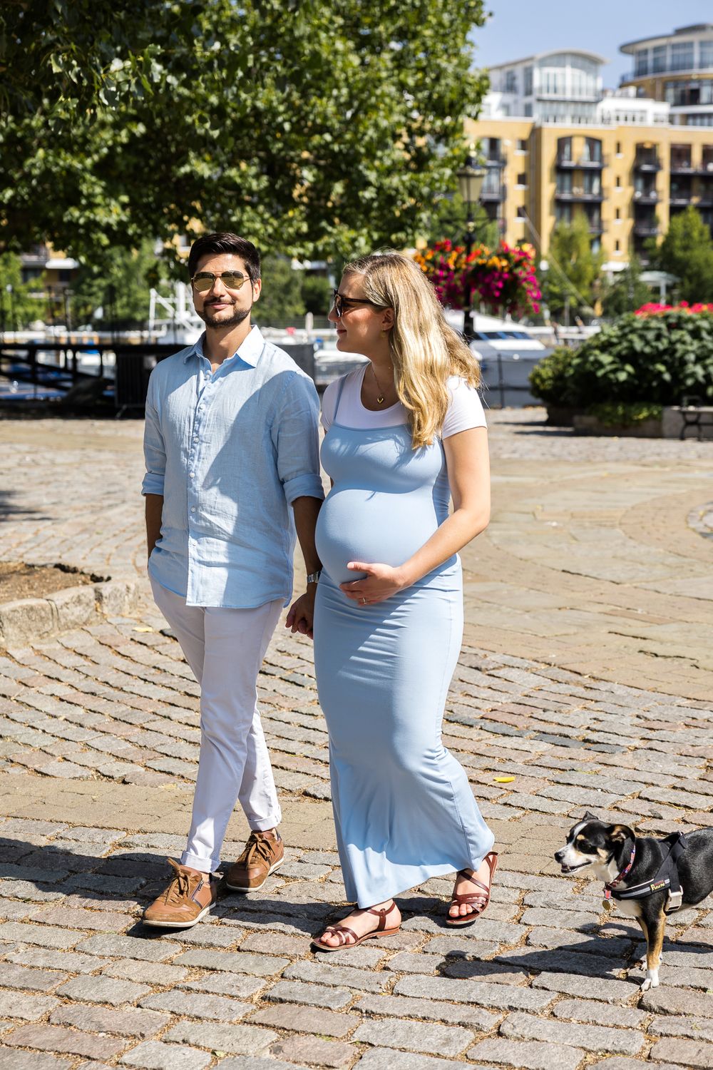 husband and wife walking around st Katharine docks with their small dog