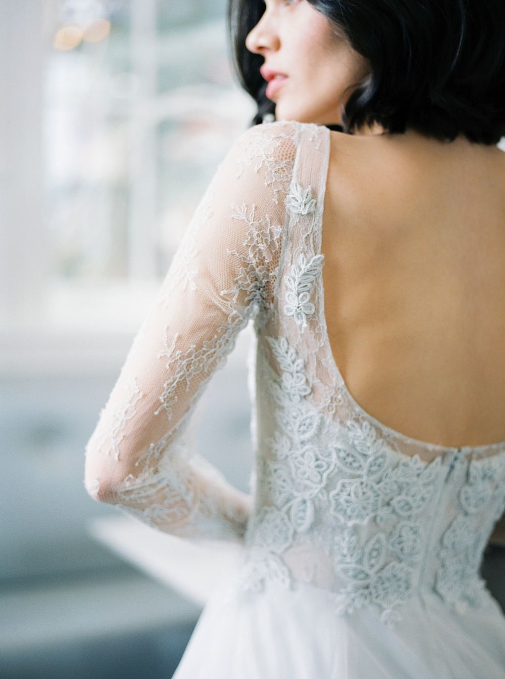 A series of close-up shots showing delicate white lace details and sheer sleeves of an elegant wedding dress.