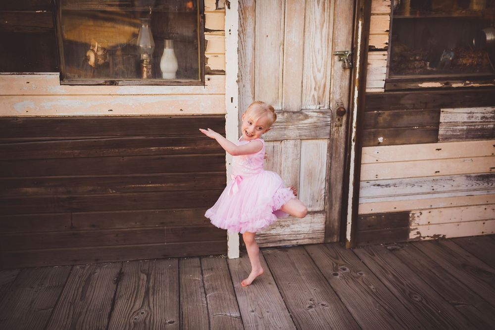 A young girl poses for annual birthday pictures on a rustic porch in Beaumont, Ca.