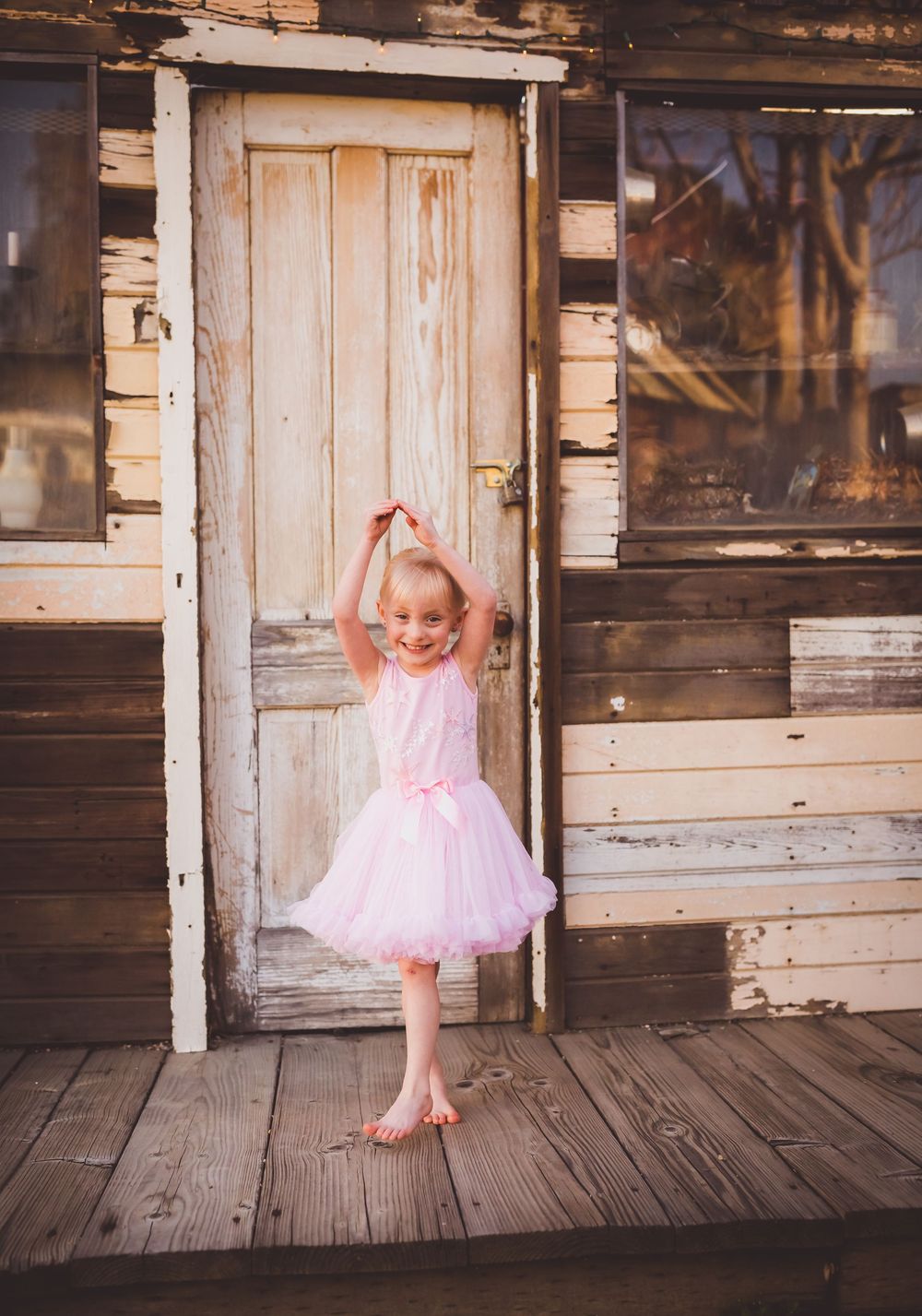 A sequence of dance poses featuring a tiny ballerina in a pink tutu on a weathered wooden porch with Heidi Grace Photography.