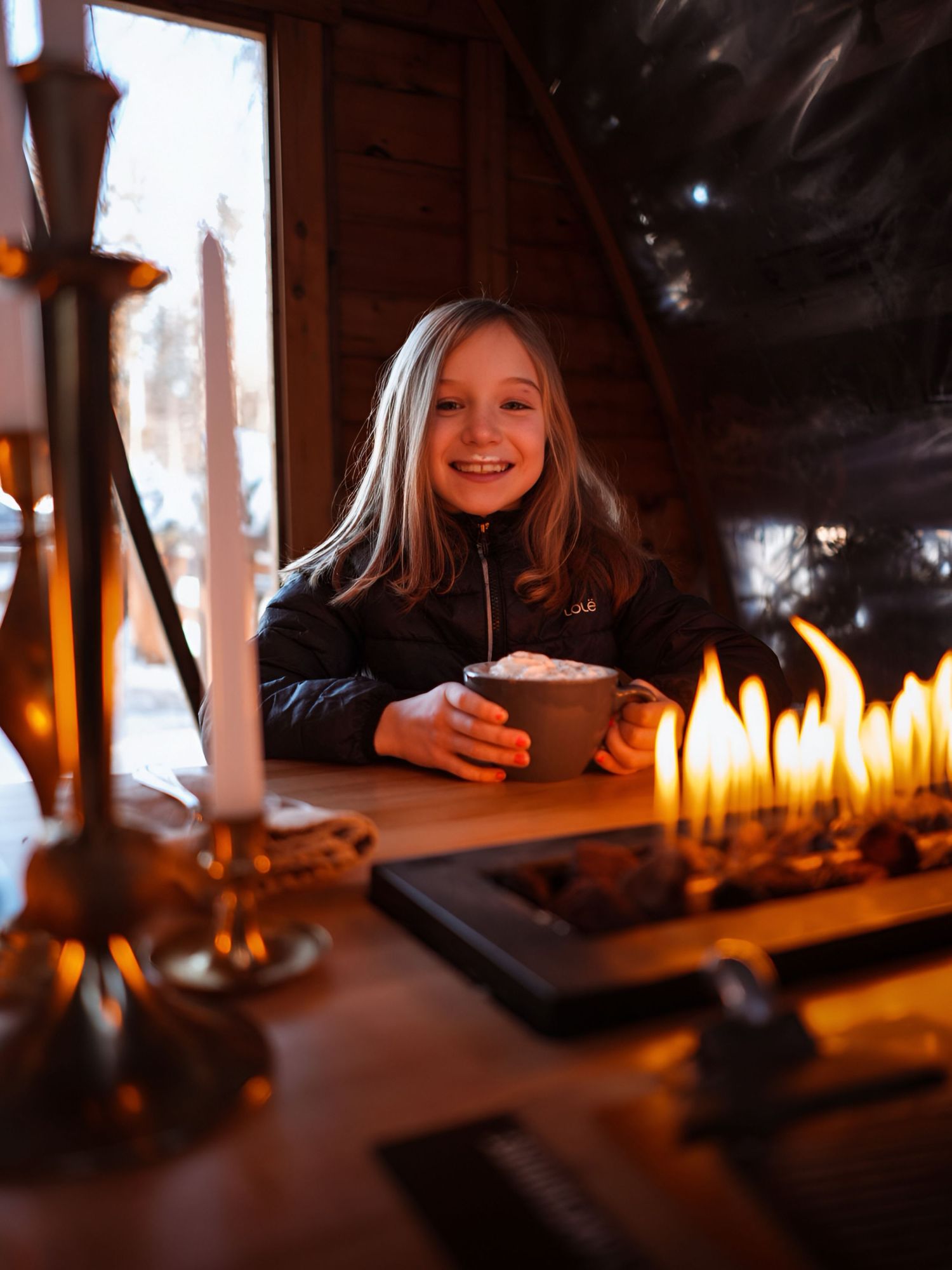A sequence of candlelit scenes showing someone enjoying a cozy evening by warm firelight.
