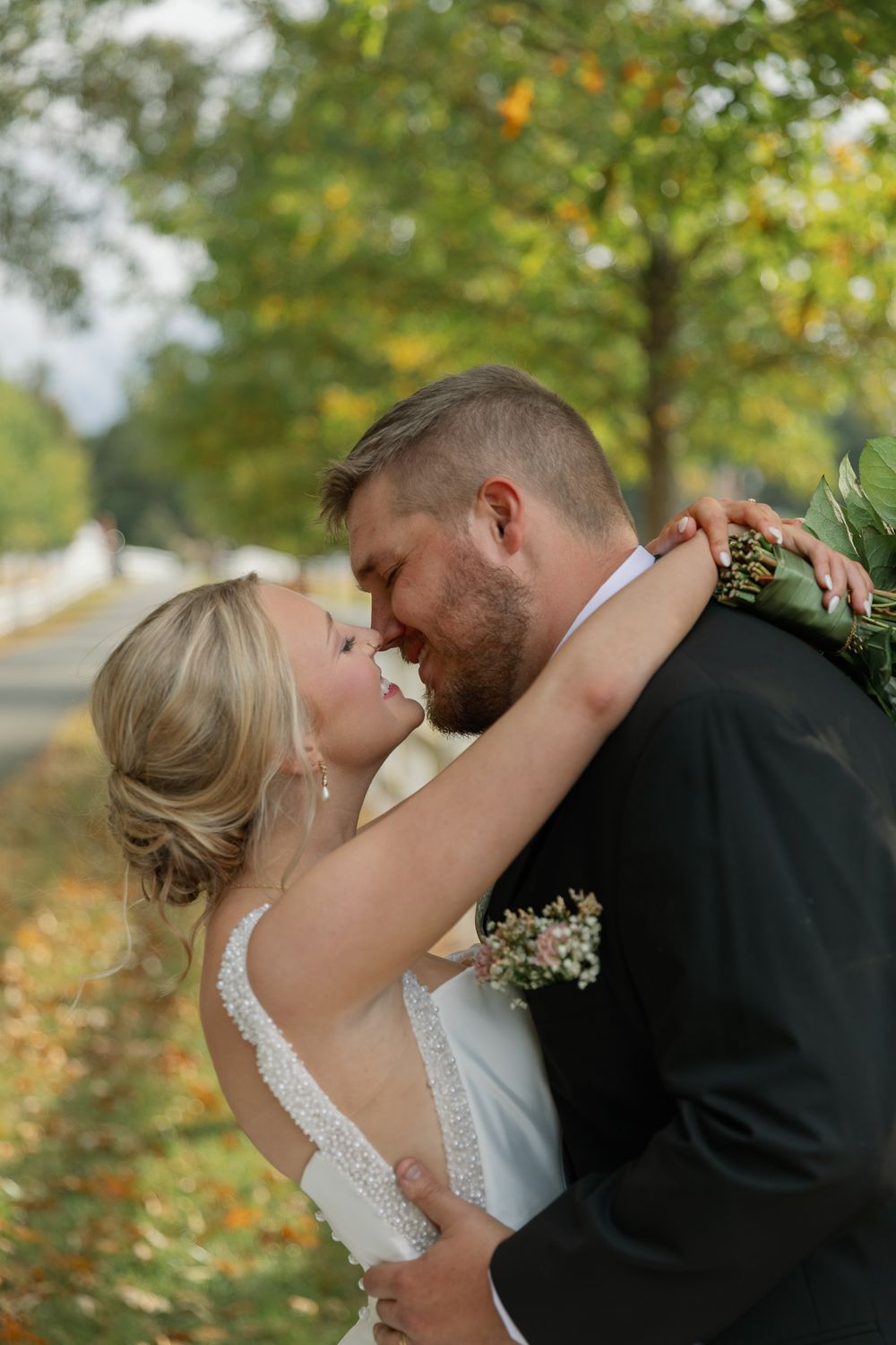 A romantic wedding kiss sequence captured in autumn with golden leaves and natural lighting in the background.
