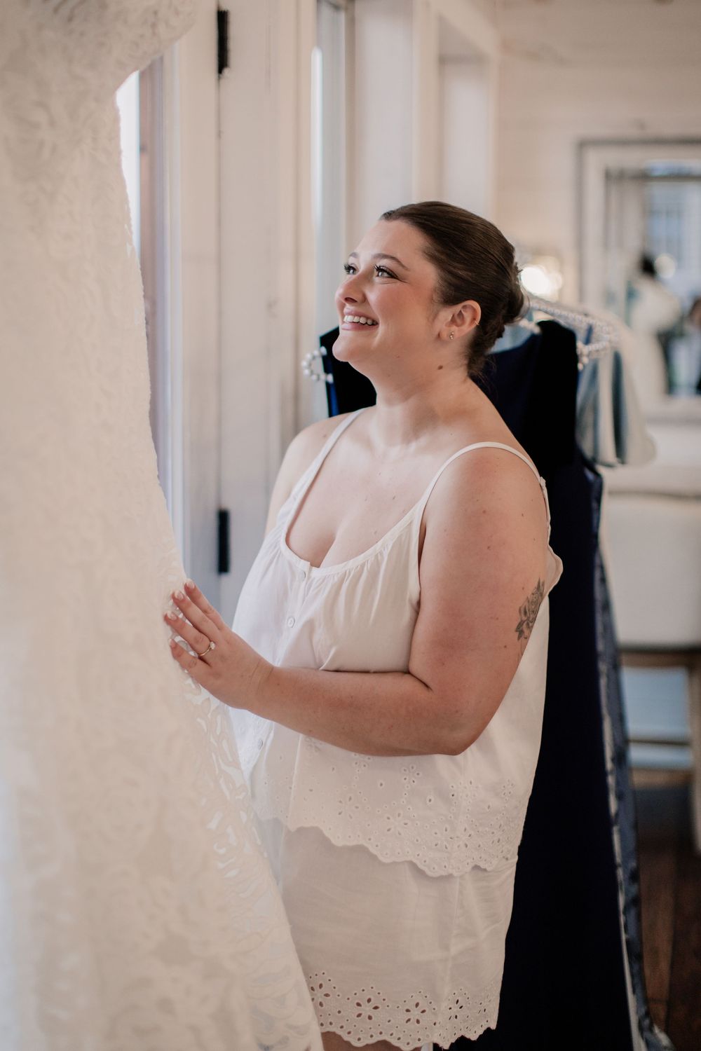 A joyful moment captured as someone in a white dress laughs while preparing for a wedding day.