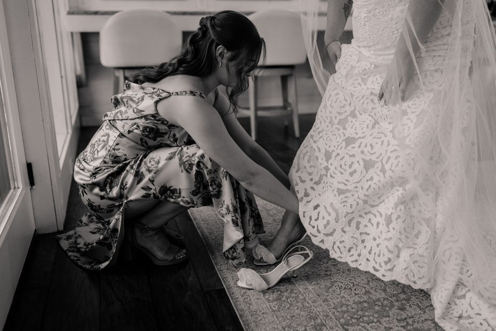 A series of black and white photos showing details of a wedding dress and decor.