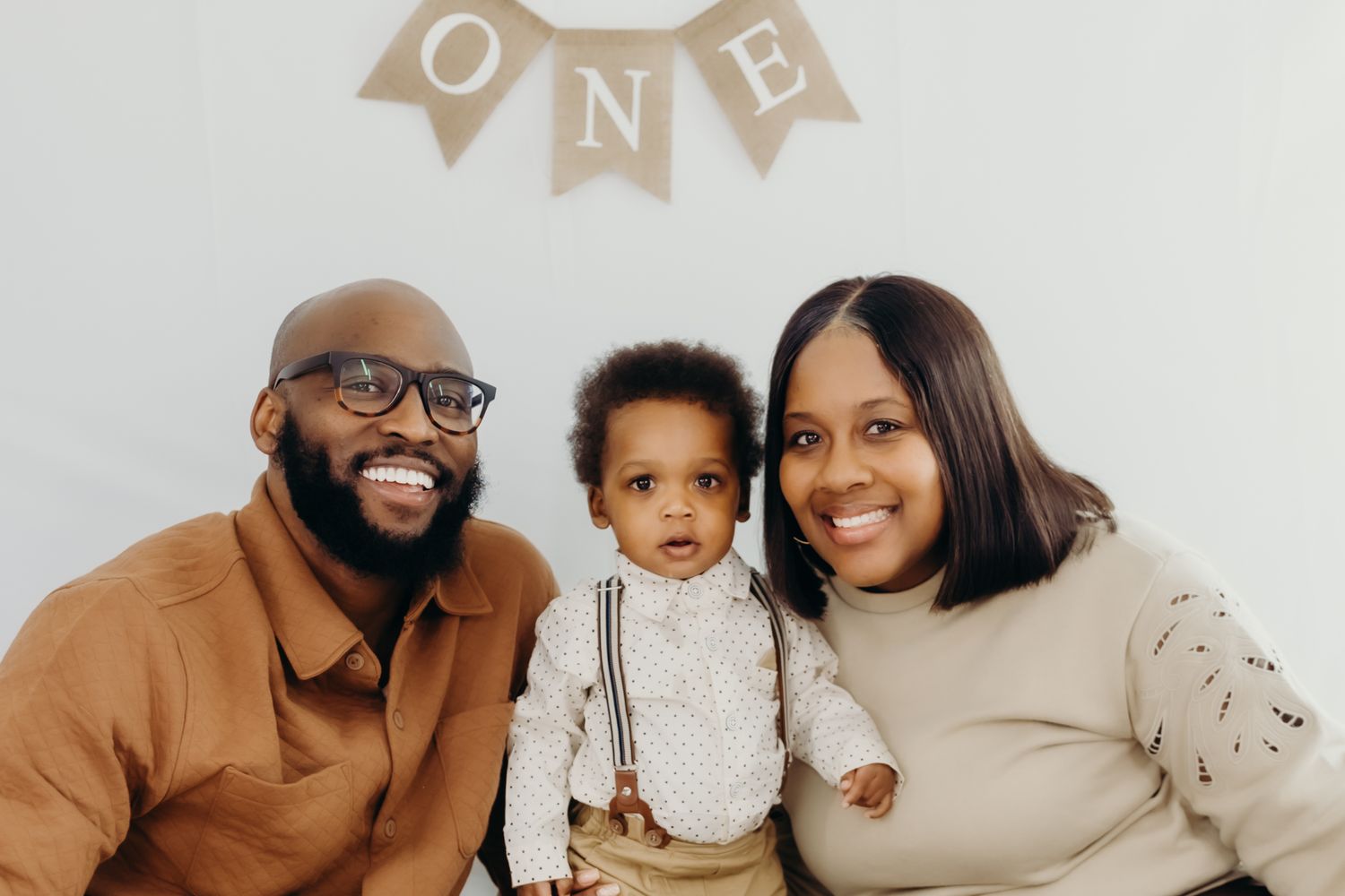 Family portrait session with neutral tones against white backdrop.