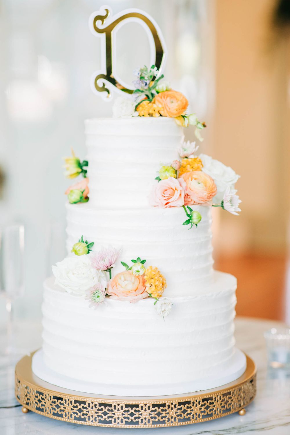 Elegant white wedding cake decorated with delicate peach and pink flowers on a gold filigree stand at 255 Milledge, Hardeman - Sams Estate