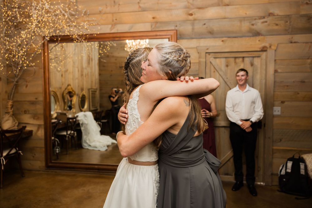 Wedding celebration in a rustic wooden barn venue with warm lighting and guests.