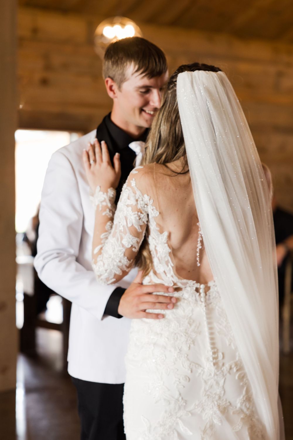 Romantic first dance moment captured in rustic barn venue.