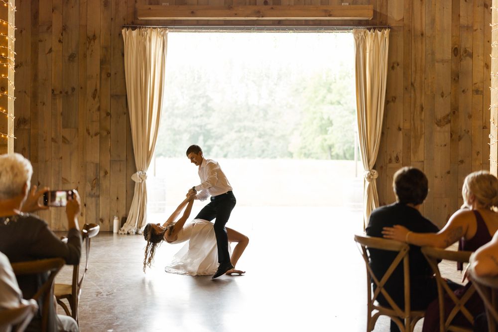 Joyful dance moments captured in rustic barn venue with natural window light.