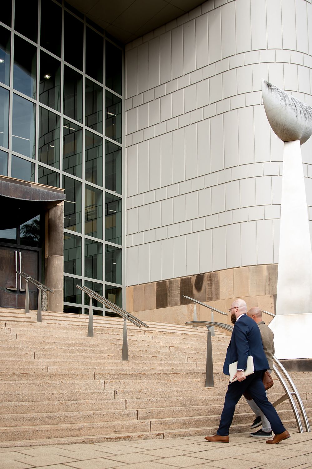 A sequence of photos showing someone falling down concrete steps while trying to slide down a handrail.