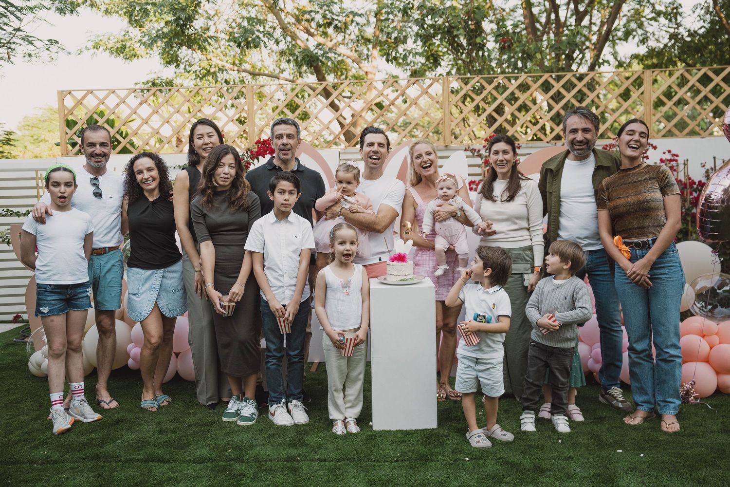 Family and friends posing together at a garden birthday event in Dubai