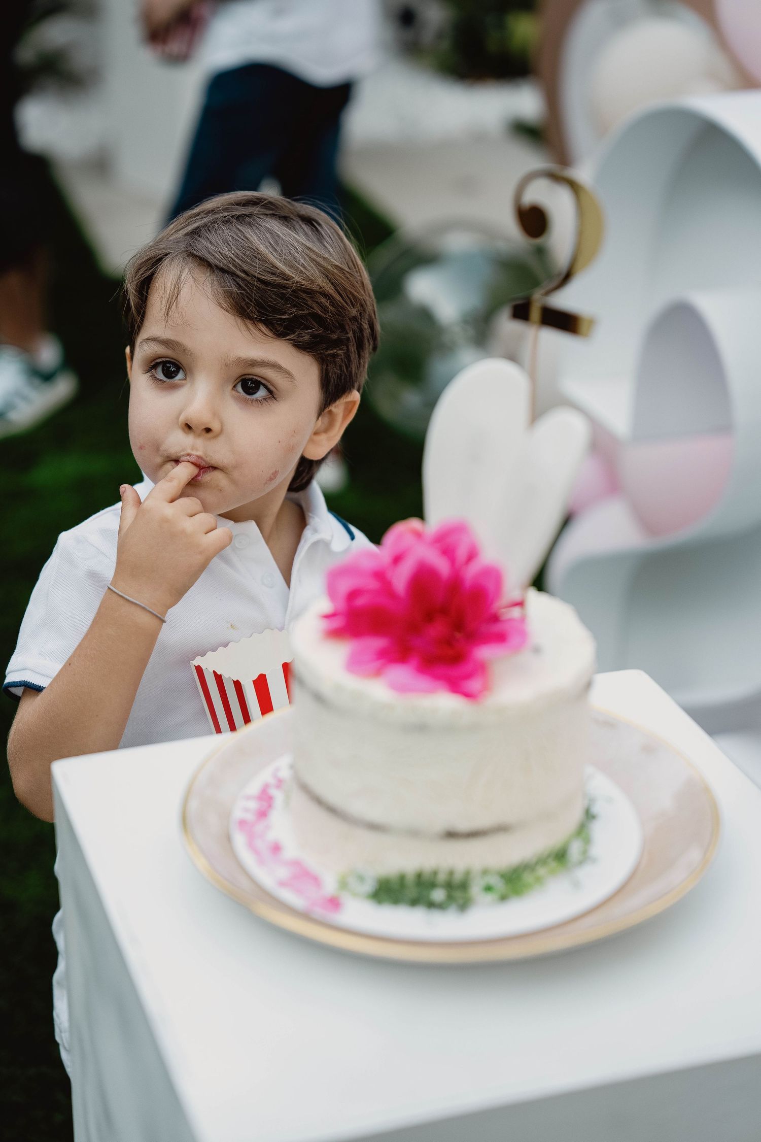Child holding a decorated birthday cake at an outdoor event in Dubai