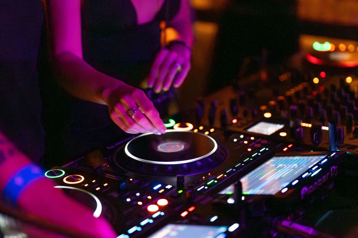 Close-up of DJ hands adjusting mixer controls