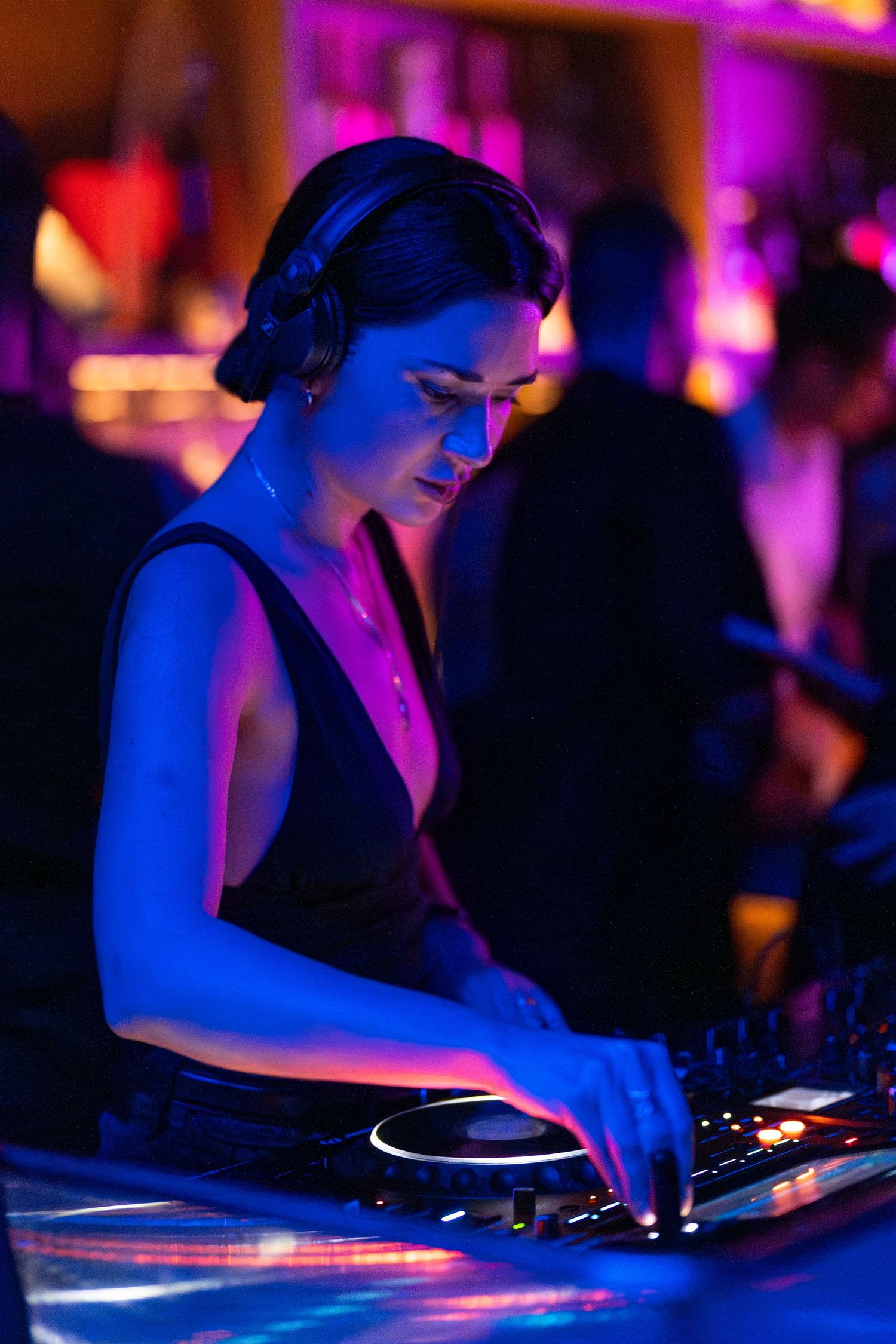 Female DJ performing live set at indoor party