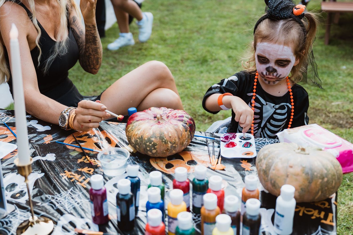 Child painting pumpkin at Halloween-themed family event