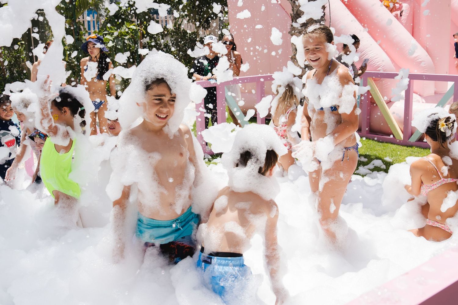 Children playing in foam during a poolside family event in Dubai
