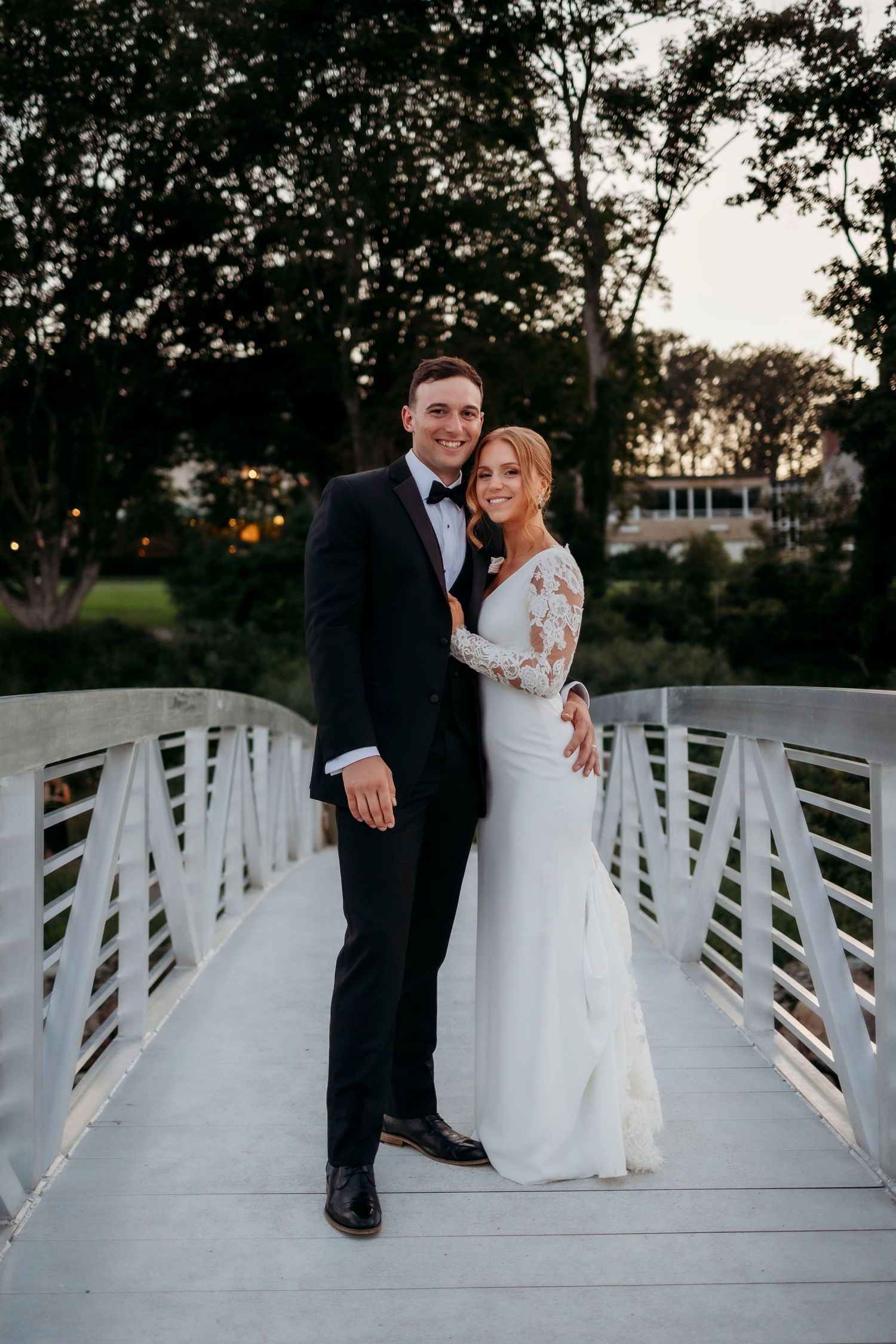 Romantic wedding photo session on white wooden bridge during sunset.