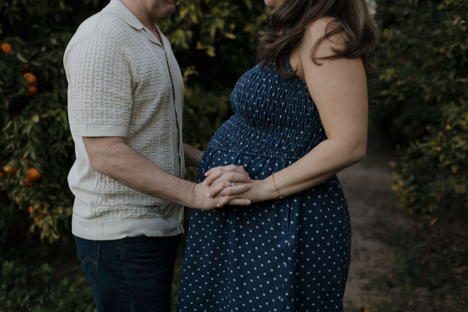Maternity photography session in a bright bedroom with white curtains and natural lighting.