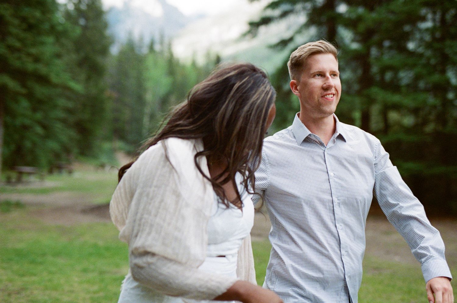 35 mm film photo of bride and groom laughing in the forest in Banff National Park