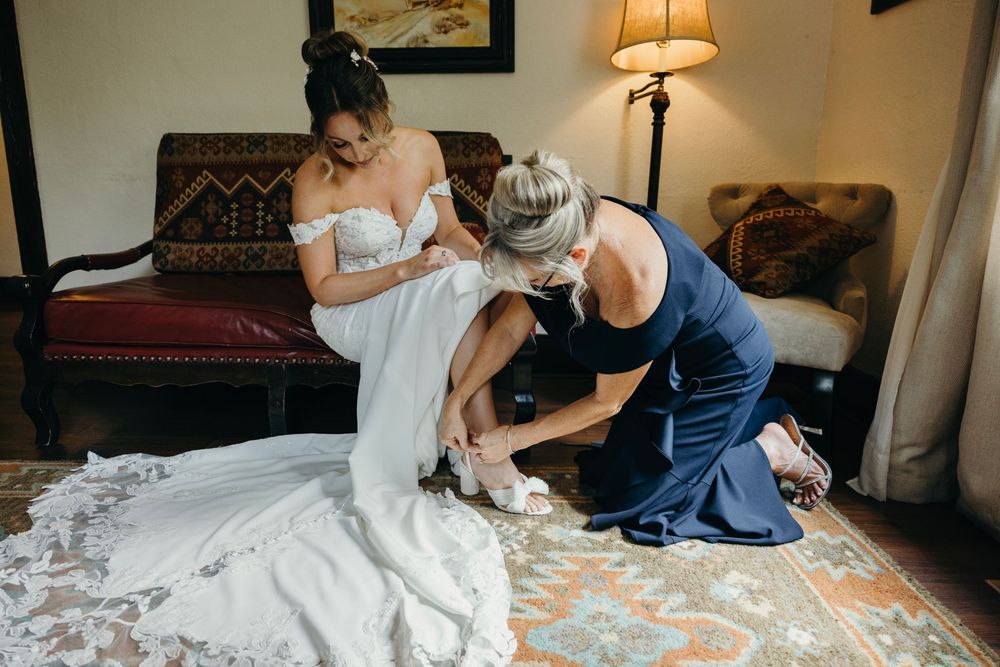 Wedding dress alterations and final adjustments being made in preparation room.