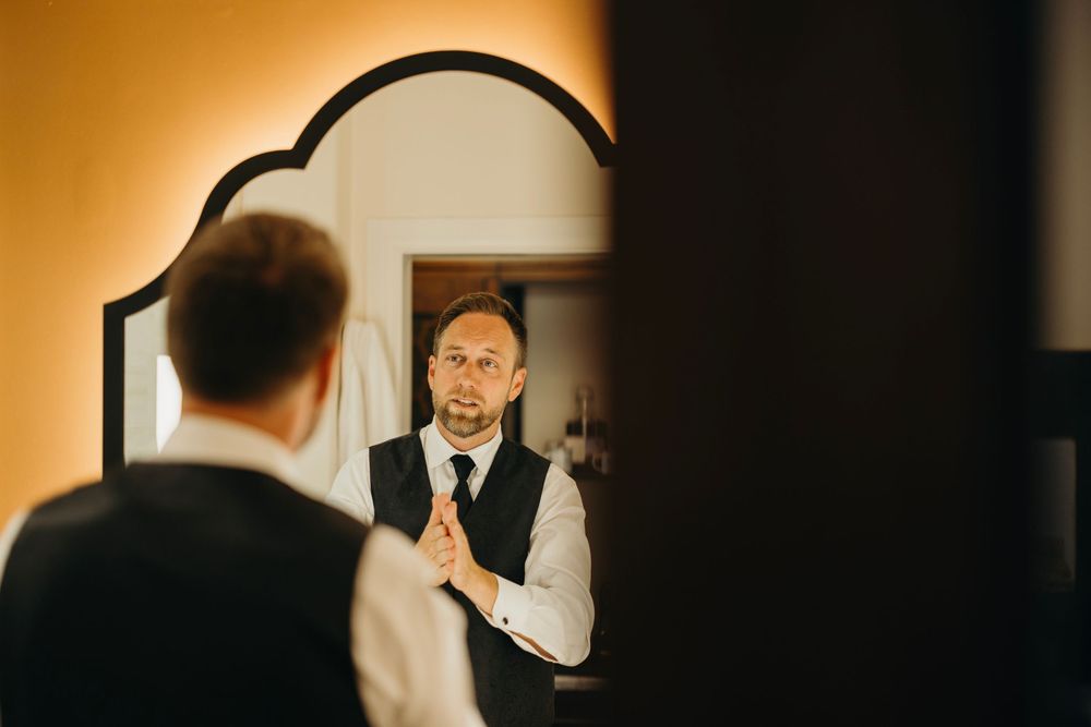 Dramatic warm-toned wedding photos captured through doorways and reflections.