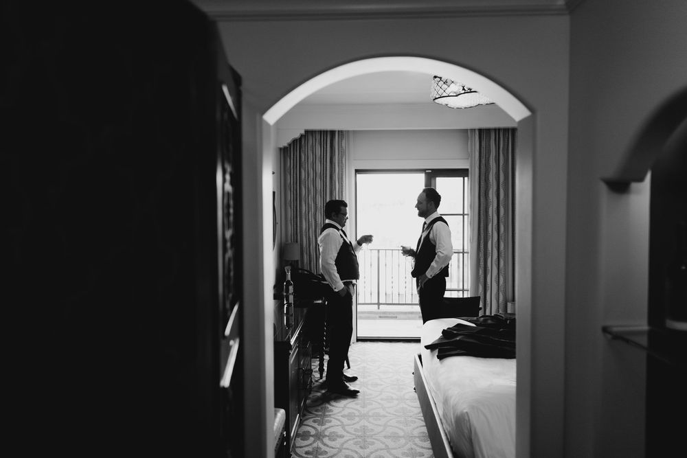Black and white silhouettes show wedding preparations through doorways and hallways.