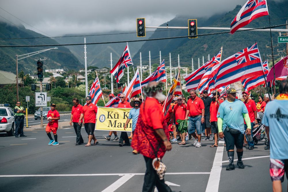 Demonstrators with Hawaiian flags march along a highway during an organized protest.